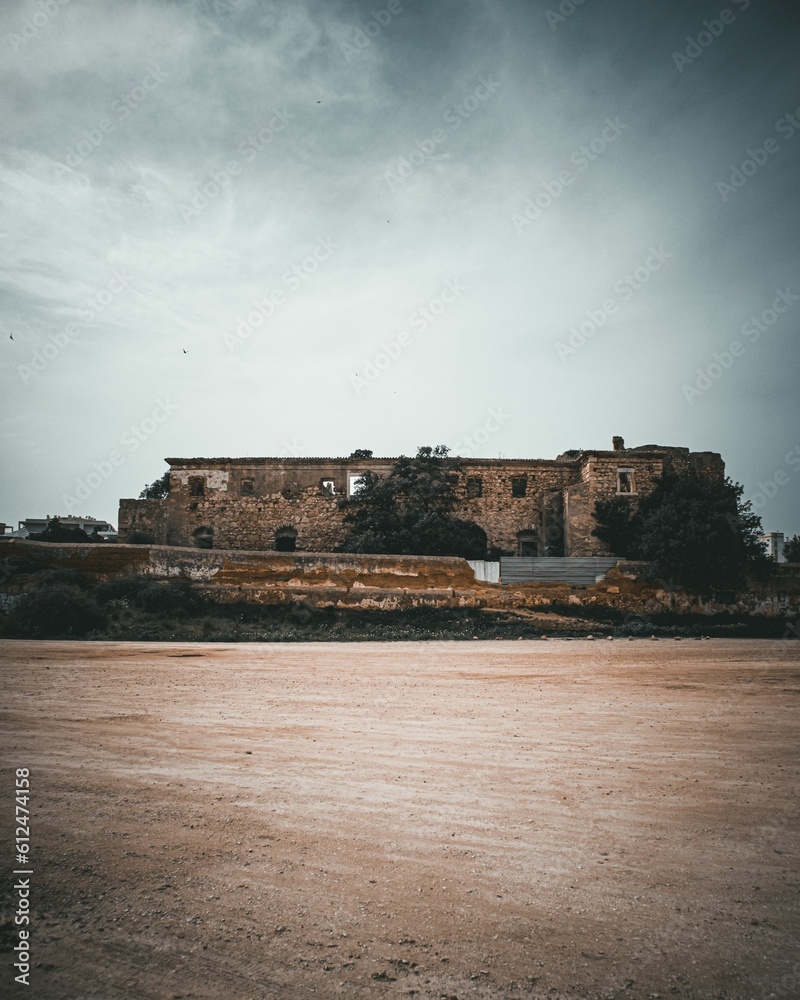 Vertical shot of old stone castle on blue cloudy sky background in Portimao, Portugal