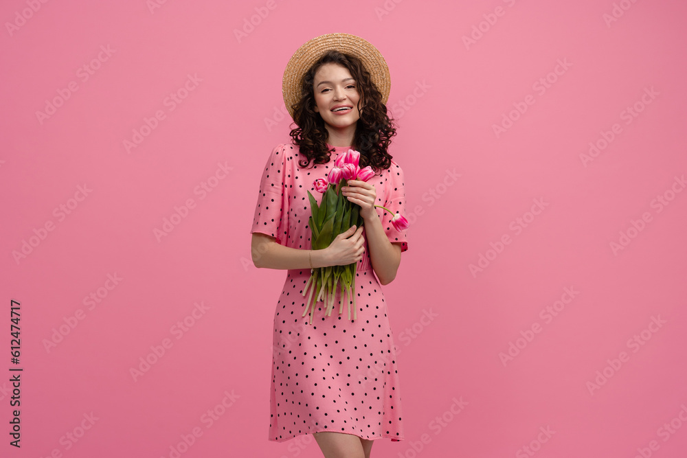 pretty young woman posing isolated on pink studio background with tulips flowers pretty young woman posing isolated on pink studio background with tulips flowers