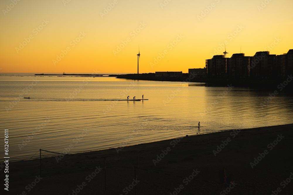 Silhouette shot of buildings and the shore of a beach during a beautiful sunset