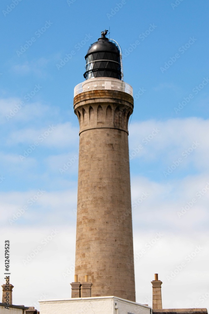 Vertical shot of a beautiful lighthouse against the sky in Highlands, Scotland
