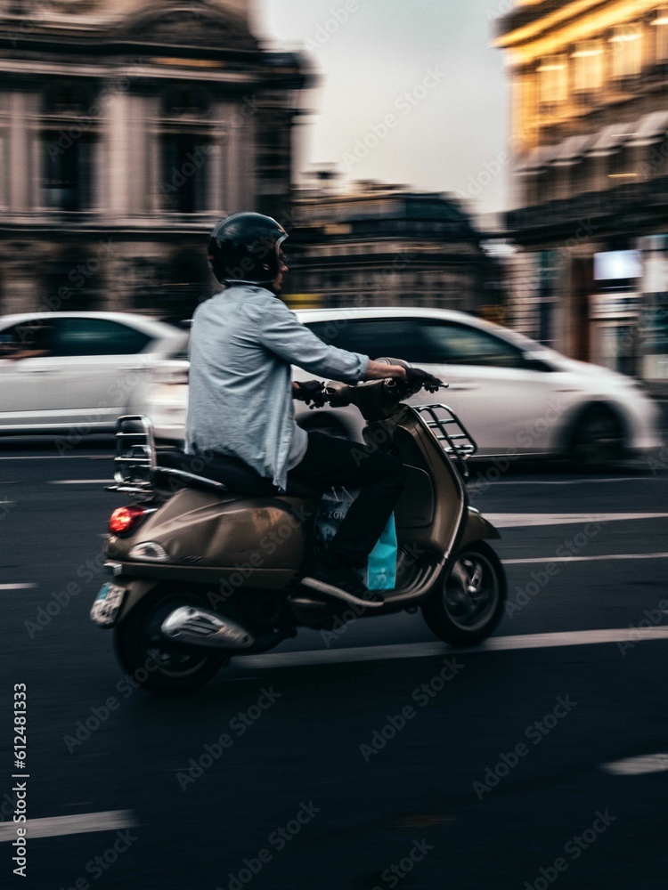 A scooter panning driving during rainy day in Paris, France