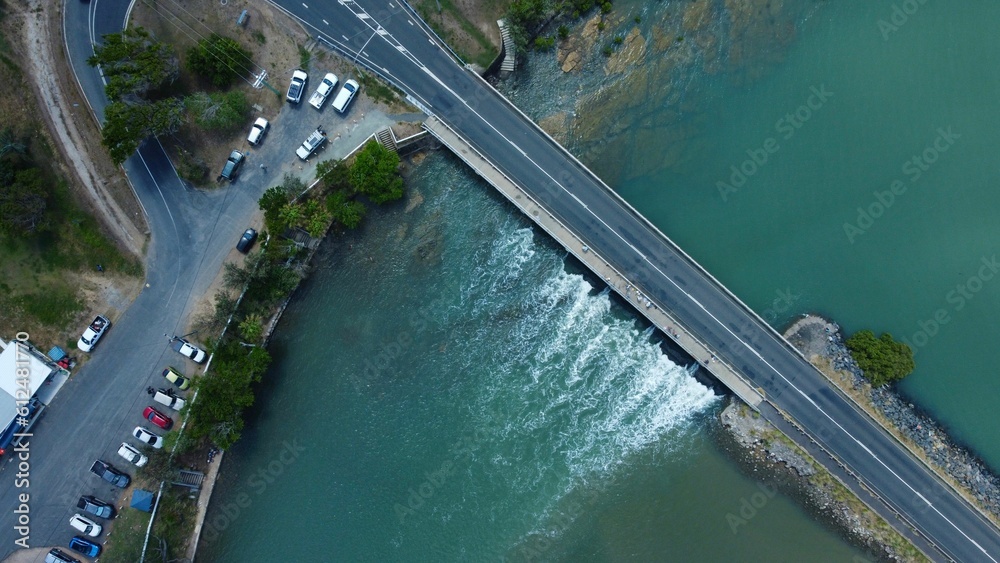 Aerial top shot of a bridge on a seascape with a road and cars