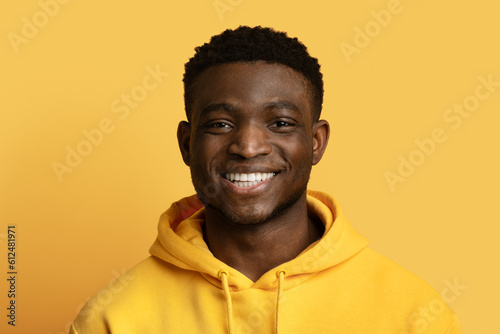 Closeup portrait of cheerful black guy posing on yellow