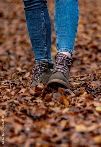 Closeup of female feet walking on fallen autumn leaves