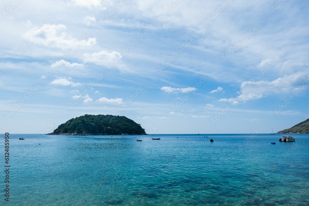 View of a small island surrounded by a tranquil ocean on a sunny day