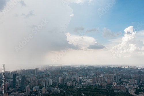 Aerial view of a city with white fluffy clouds in the sky © Zhou Chenxiao/Wirestock Creators