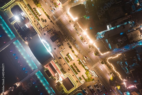 Drone shot of illuminated streets with cars and skyscrapers buildings at night