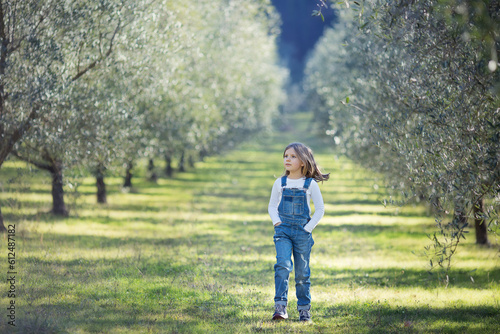 Girl walking though olive tree in Italy © Olga
