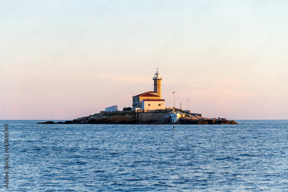 Lighthouse on the islet in blue sea near Rovinj, Croatia
