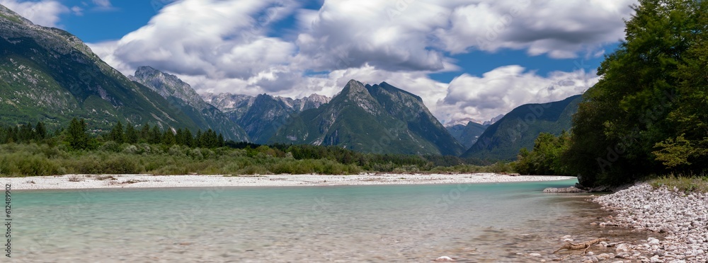 Panoramic landscape of Julijske Alpe Mountain range in lake water and wood trees in Slovenia