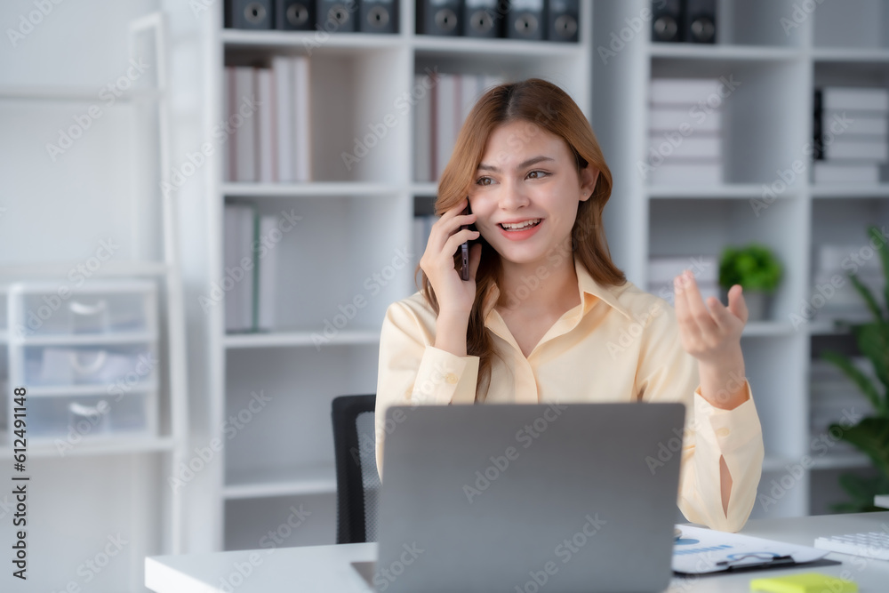 Happy beautiful smiling businesswoman talking on mobile phone whith laptop working in office. Happy beautiful smiling businesswoman talking on mobile phone whith laptop working in office.