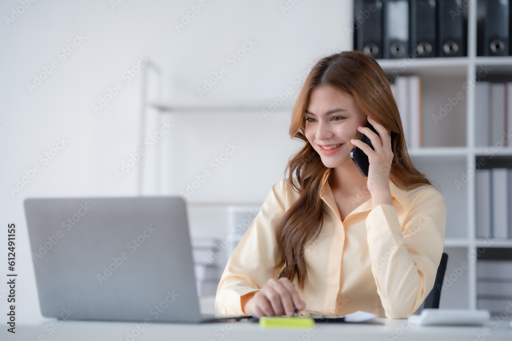 Happy beautiful smiling businesswoman talking on mobile phone whith laptop working in office. Happy beautiful smiling businesswoman talking on mobile phone whith laptop working in office.