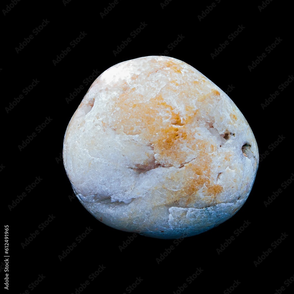 Closeup shot of a pebble from the beach isolated on the black background Closeup shot of a pebble from the beach isolated on the black background