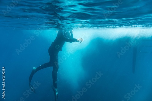 Person diving in dark night water with his head on dry land
