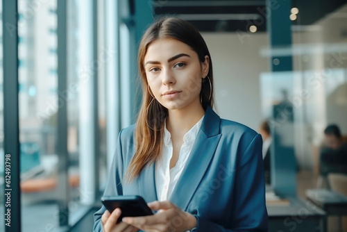 Portrait of a pretty young business woman using smarthphone in her office