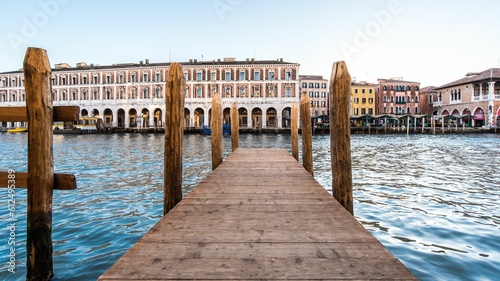 Pier in front of a beautiful lake surrounded by gorgeous buildings in Venice, Italy © Burgie/Wirestock Creators