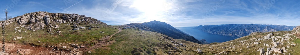 Panoramic shot of the landscape over the mountains and the blue sea from the peak on a sunny day