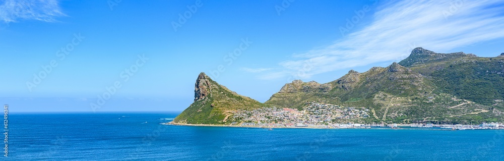 Panoramic shot Hout Bay with rugged coastal mountain and blue sea