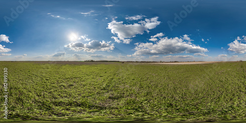 spherical 360 hdri panorama among green grass farming field with clouds on blue sky with sun in equirectangular seamless projection  use as sky replacement  game development as skybox or VR content