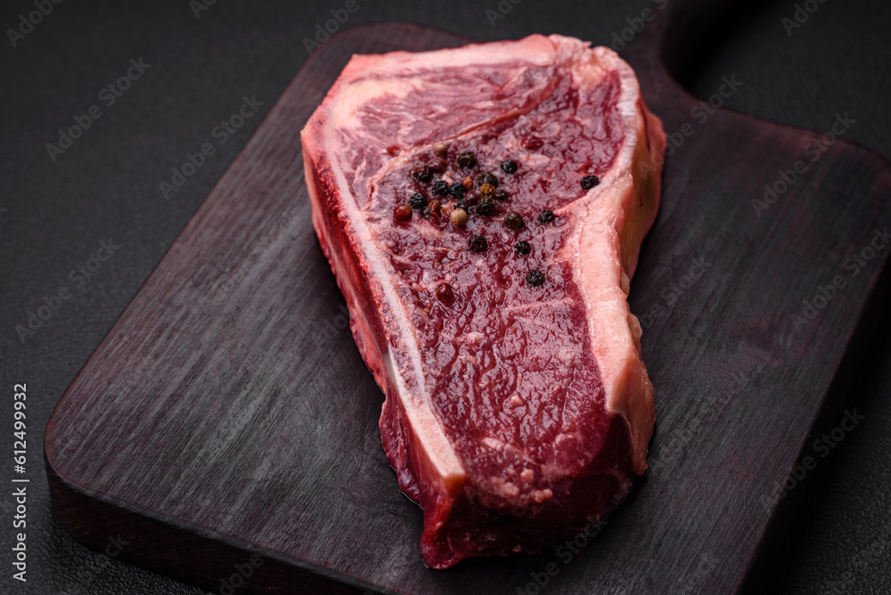 Fresh juicy raw new york beef steak with salt, spices and herbs