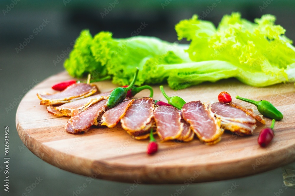 Cut ham slices and lettuce on wooden plate Cut ham slices and lettuce on wooden plate