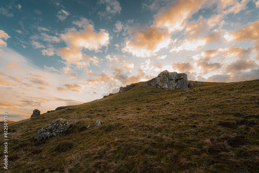 Beautiful shot of a cloudy sunset sky over a rural hill with stone formations in Baden-Wurttemberg