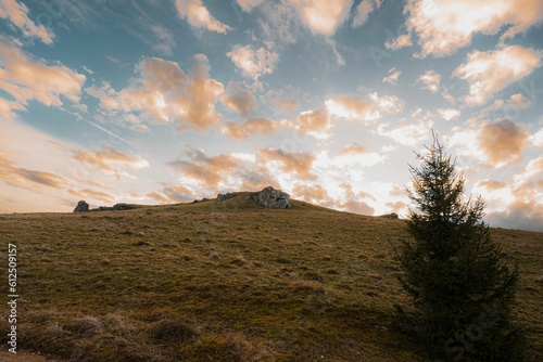 Beautiful shot of a cloudy sunset sky over a rural hill with stone formations in Baden-Wurttemberg
