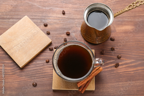 Drink coasters with cup of coffee, cinnamon and jezve on wooden table