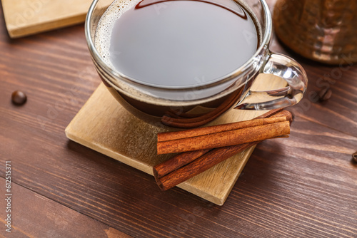 Drink coasters with cup of coffee and cinnamon on wooden table