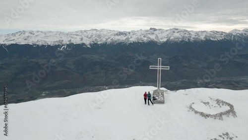 Drone footage filming Dent de Crolles mountain with snowy ridged and h a Christian cross photo