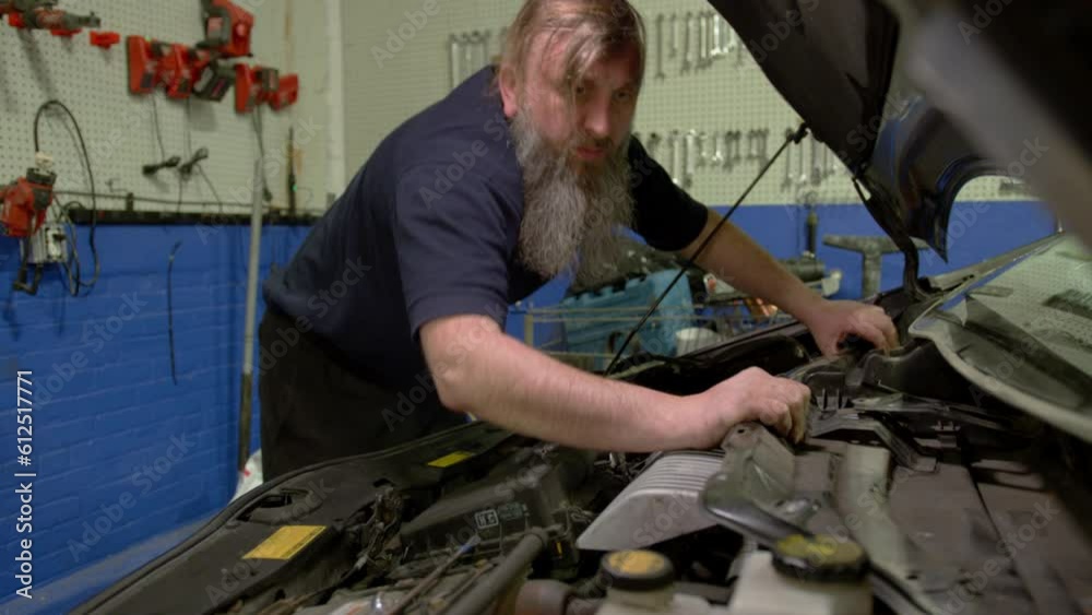 Car mechanic replacing car at repair service station Car mechanic replacing car at repair service station