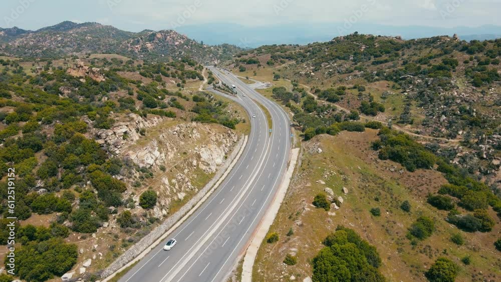Asphalt winding highway passing through mountain. Road goes into distance to horizon background mountain. Aerial view Asphalt winding highway passing through mountain. Road goes into distance to horizon background mountain. Aerial view