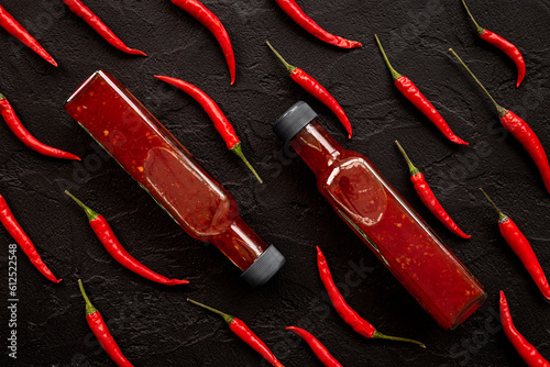 Red chili sauce ketchup or tabasco with ripe hot pepper photo