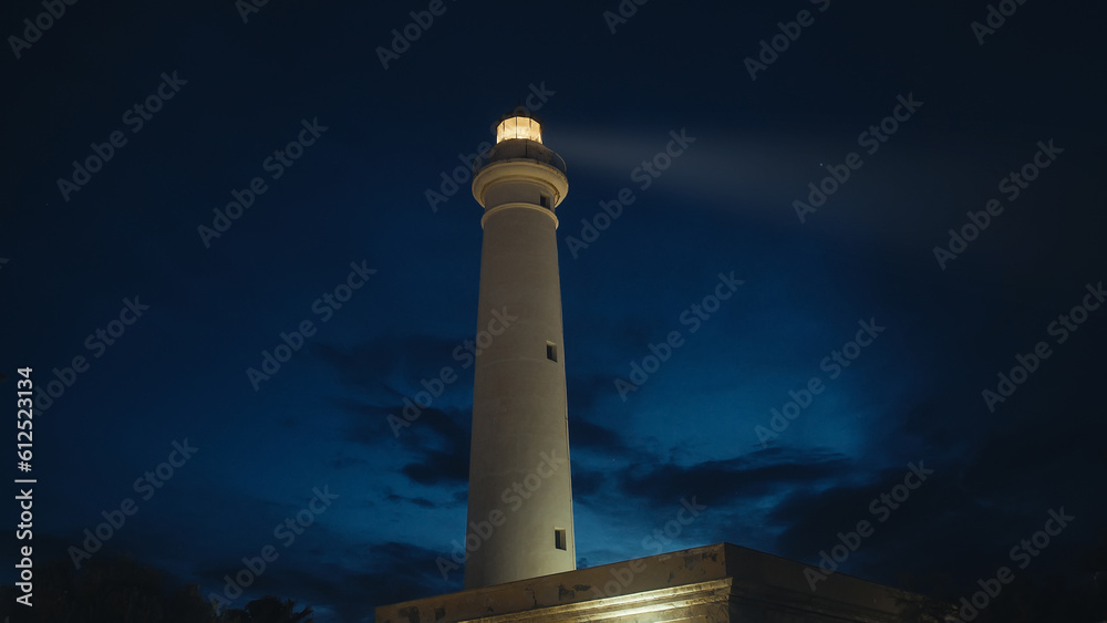 Lighthouse beam in the night near the full moon