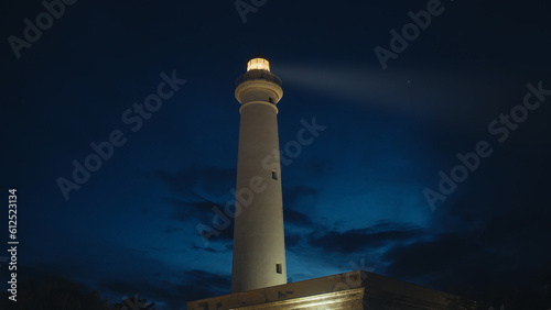 Lighthouse beam in the night near the full moon