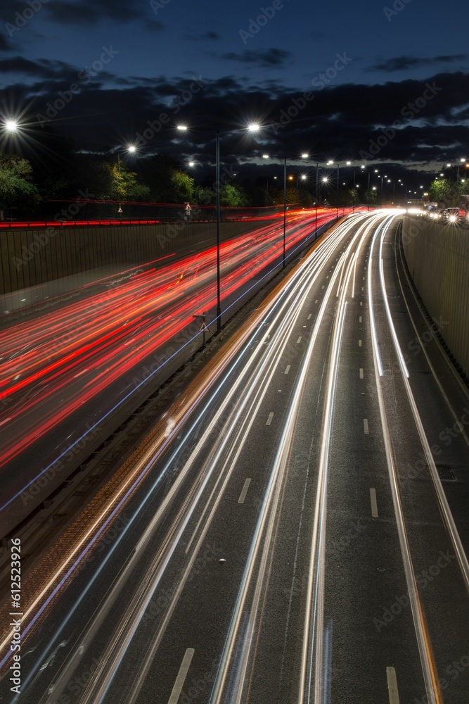 Light trails from speeding cars on the A40 highway in Perivale, London, UK, during the early evening