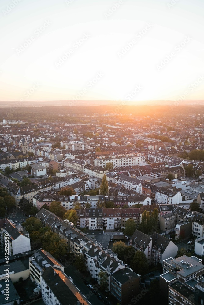 Obraz premium A vertical shot of a sunset over a large city. It's summer and the sun is shining in Cologne.