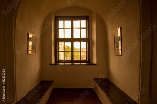Interior of a cozy room with a window and wooden benches