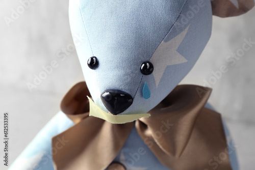 Toy bear with taped mouth a...