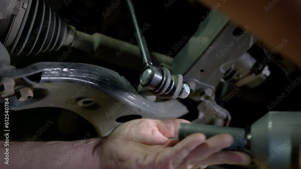 Car mechanic replacing car at repair service station Car mechanic replacing car at repair service station