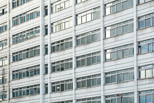 Outdoor shot of the exterior of a white building with many windows