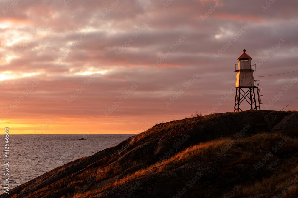 Beautiful sunset over the lighthouse on the hill in Henningsvaer, Lofoten Islands, Norway.