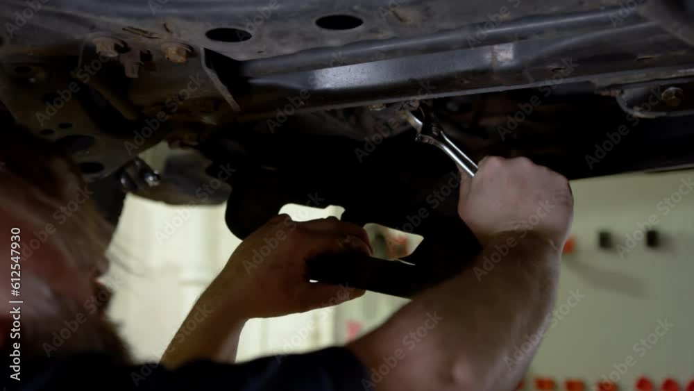 Man maintenance of his car in a garage Man maintenance of his car in a garage