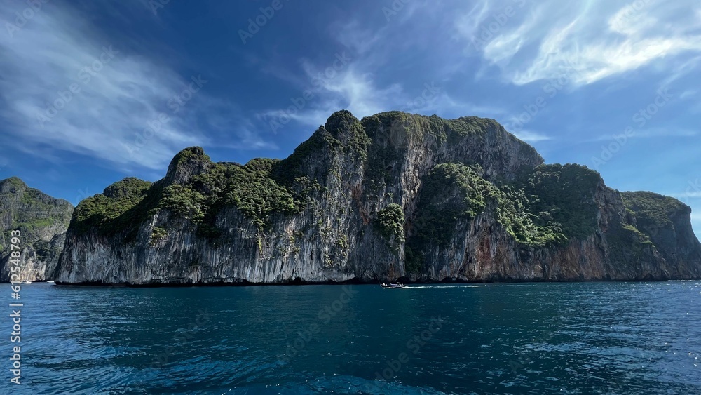 Scenic shot of a green-covered rocky island under the blue sky in Thailand