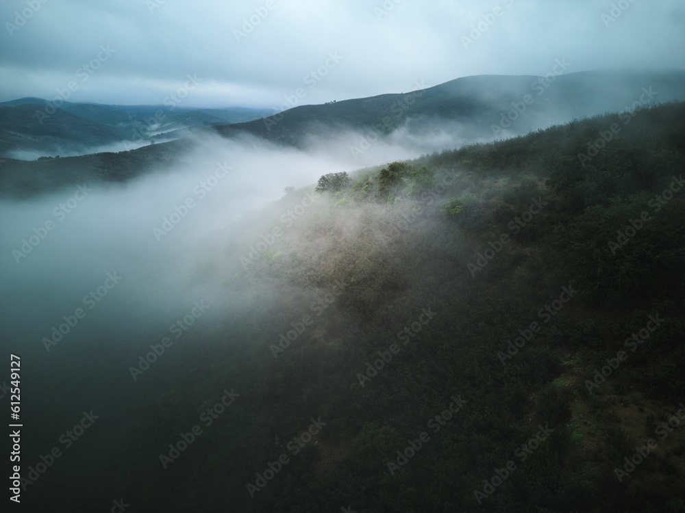 Aerial shot of the misty Serra de Caldeirao Mountain range in Portugal