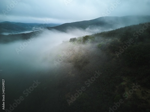 Aerial shot of the misty Serra de Caldeirao Mountain range in Portugal photo