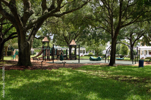Fototapeta Naklejka Na Ścianę i Meble -  Playground for kids in a beautiful residential neighborhood park full of trees on a sunny day in Florida