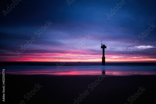 Distant shot of a distant building and its reflection on the seawater at a vibrant sunset