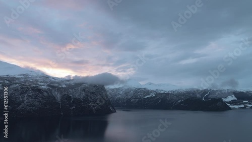 Aerial of the fjord surrounded by the snowy mountains in Sunnmore, Norway on a gloomy day photo