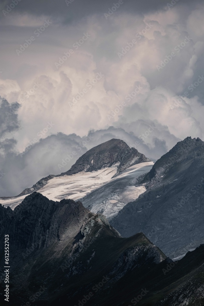 Aerial view of snow covered mountain landscape under clouds Aerial view of snow covered mountain landscape under clouds